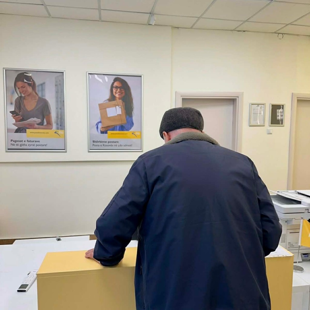 Qytetar në banakun e shërbimit në zyrën postare.